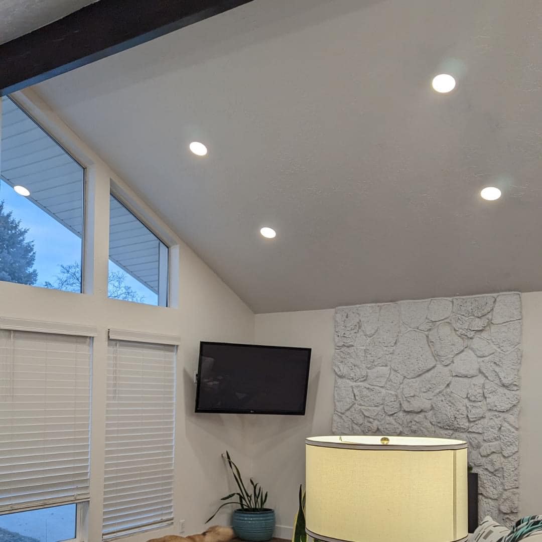 Same vaulted ceiling with five new recessed LED lights installed and glowing