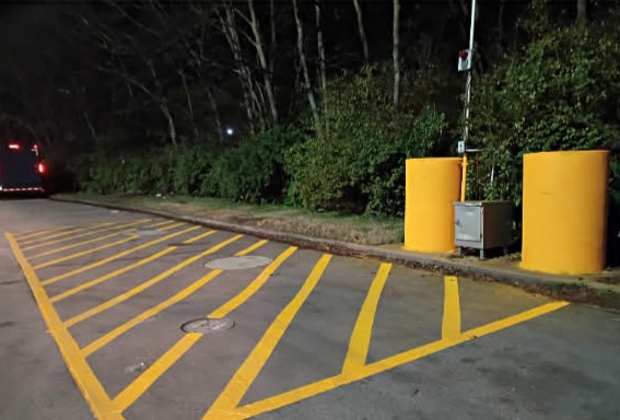 Freshly painted bright yellow parking lot stripes and newly painted yellow bollards after restriping